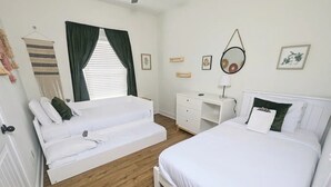 Une chambre comprenant un lit, un canapé-lit, un bureau et un miroir.