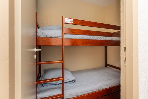 A bunk bed with a wooden frame and a single mattress on the lower bunk. - Blue Pinsolle - Appt avec piscine partagée (Soustons)