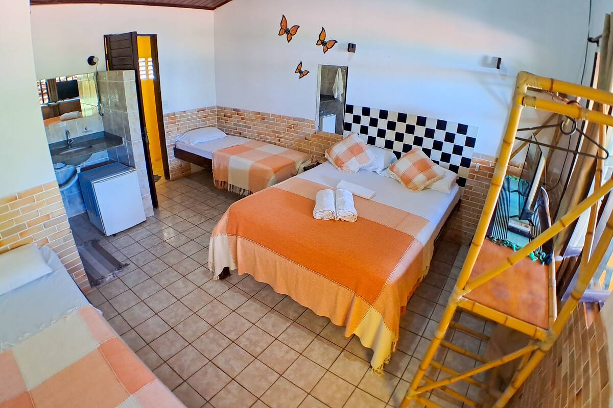 Une chambre d’hôtel avec deux lits, une petite salle de bain et un mur à carreaux.