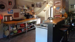 Una cocina con encimera de madera, electrodomésticos de acero inoxidable y una lámpara colgante.