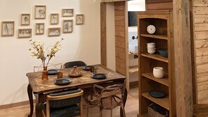 Comedor con mesa de madera, sillas y lámparas de mimbre colgantes.