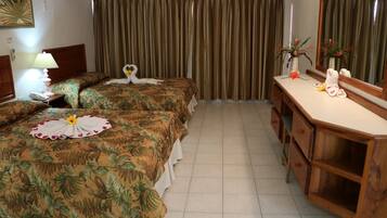 Una habitación de hotel con dos camas, un aparador de madera, un espejo y una cortina.