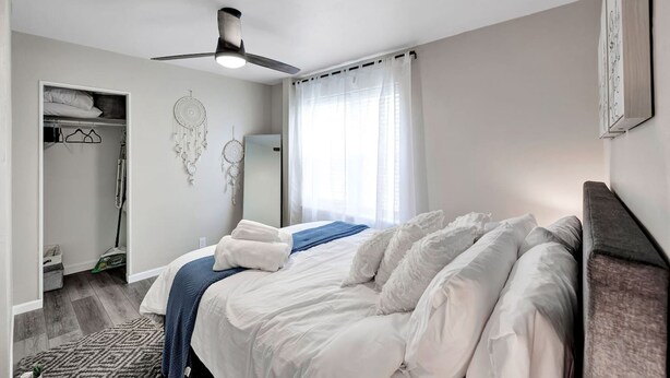 A neatly arranged bedroom with a bed, a ceiling fan, a wardrobe, and a dreamcatcher on the wall. - Newly Renovated - Must Stay at in Algoma (Algoma)