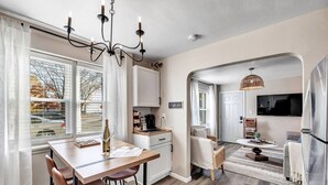 A modern kitchen with a dining area, a coffee bar, and a living space with a TV. - Newly Renovated - Must Stay at in Algoma (Algoma)