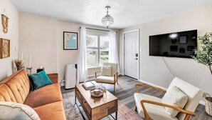 A modern living room with a sofa, armchairs, a coffee table, and a TV mounted on the wall. - Across the Street From Von Stiehl-newly Renovated (Algoma)