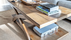 A wooden coffee table with a stack of books, a tray with stones and a spoon, and a suitcase on it. - Newly Renovated - Walking Distance to Pier (Algoma)