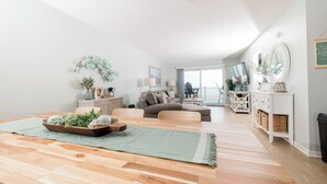 Un salon moderne avec une table à manger en bois, un canapé et une vue sur l’extérieur.