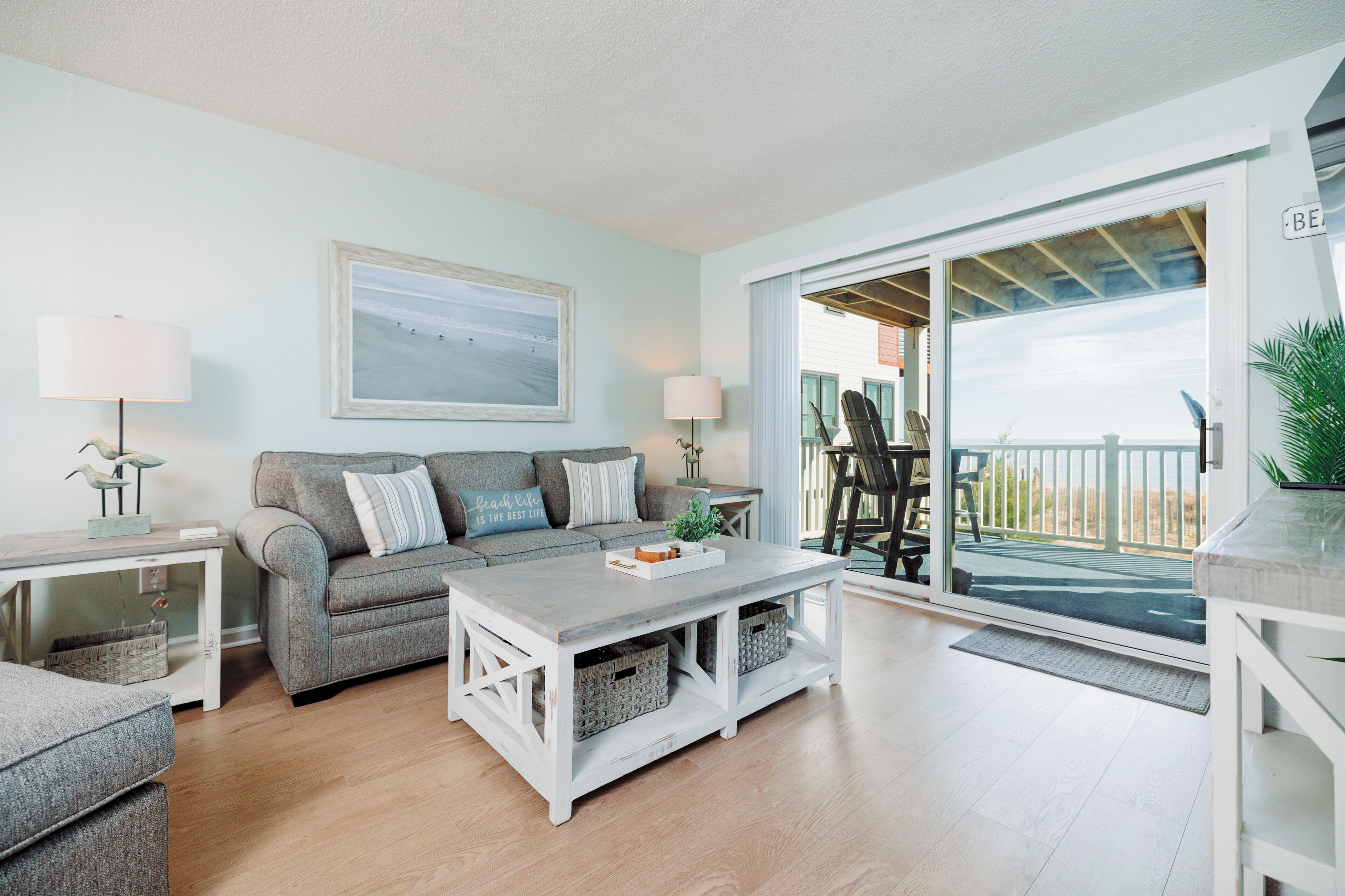 A living room with a sofa, coffee table, and a view of the outside.