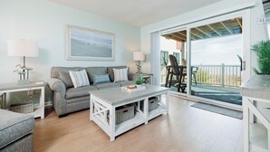 Un salon avec un canapé, une table basse et une vue sur l’extérieur.
