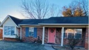 A two-story house with a front porch, a garage, and a small front yard.