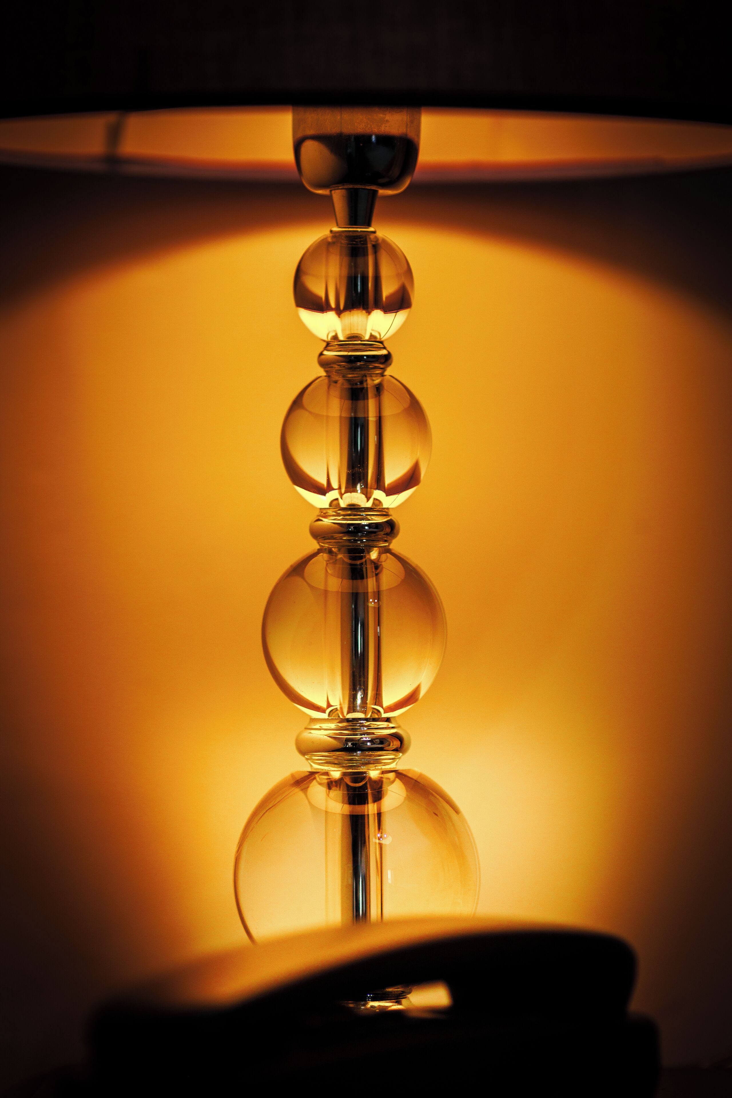 Un gros plan d’une lampe dotée d’un abat-jour en verre transparent et d’une lumière chaleureuse.