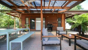 An outdoor patio with wooden furniture, a ceiling fan, and a barbecue grill. - Sanctuary 33 - Your private haven near the river (Bright)