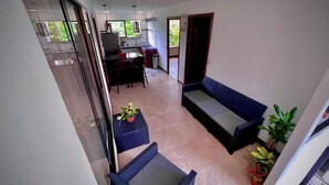 Un balcó espaiós amb zona de seients, taula de dinar i cuina al fons.