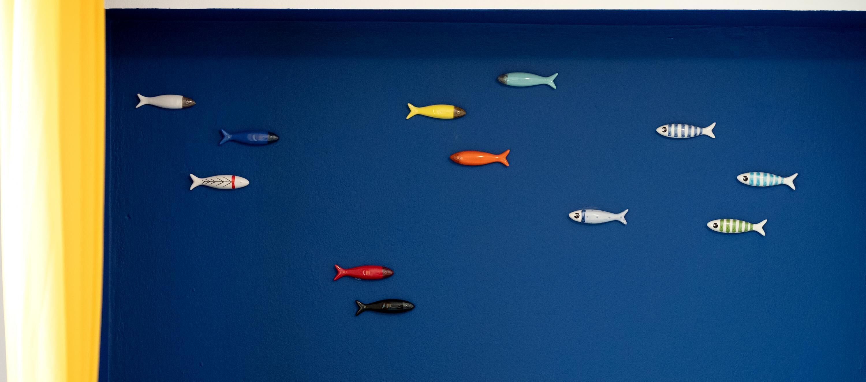 A collection of small, colorful fish models on a blue background.