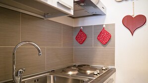 Cozinha moderna com eletrodomésticos de aço inoxidável, uma pia dupla e azulejos de madeira na parede.