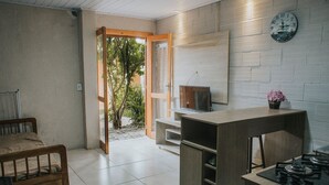 Eine kleine Küche mit Holztisch, Gasherd, Fernseher und einem kleinen Schrank.