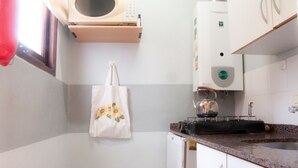 Standaard appartement | Privékeuken | Een microgolfoven, kookgerei, borden en bestek