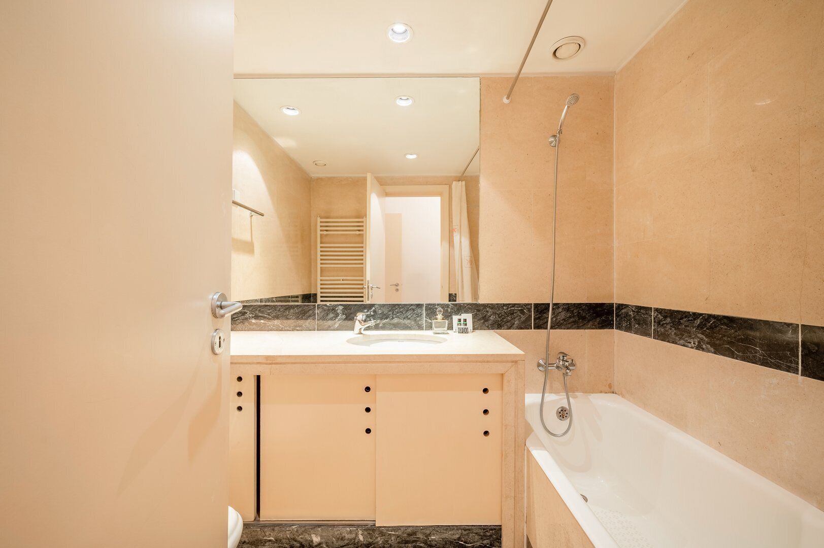 A modern bathroom with a bathtub, a shower, and a vanity with a sink.
