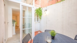 An outdoor patio with a round table, chairs, and a potted plant. - GuestReady - Delightful getaway in the city centre (Lisbon)