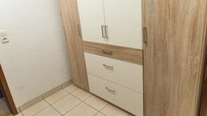 A room with a wardrobe featuring a wooden finish and a white door. - Reiterhof Finkenmühle Fewo Gipsy (Weißenstadt)