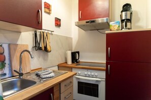 Geladeira, cafeteira/chaleira, cadeirão de bebê