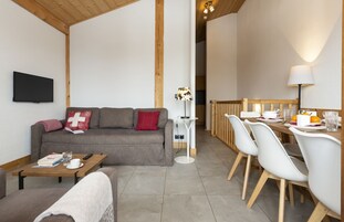 A living area with a sofa, coffee table, and dining table with chairs.