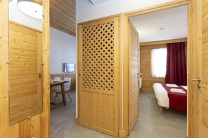 Una habitación de madera con una cama, un escritorio y un televisor.