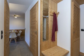 A wooden interior with a dining area, a mirror, and a towel rack. - Residence Odalys Les Fermes De Chatel (Chatel)