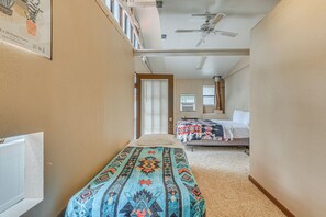 A narrow hallway leading to a bedroom with a bed, a window with blinds, and a ceiling fan. - Ruidoso Retreat w/ Grill ~ 3 Mi to Grindstone Lake (Ruidoso)