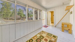 A spacious room with large windows, a wooden staircase, and a patterned rug. - Ruidoso Retreat w/ Grill ~ 3 Mi to Grindstone Lake (Ruidoso)