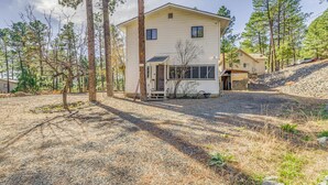 A two-story house with a garage, surrounded by pine trees and a gravel driveway. - Ruidoso Retreat w/ Grill ~ 3 Mi to Grindstone Lake (Ruidoso)