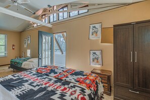 Un dormitorio con cama, armario, ventana y puerta.