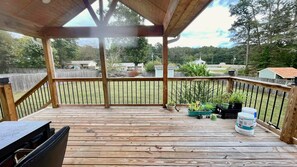 A wooden deck with a covered area, potted plants, and a grill. - Cozy 3-Bedroom Home w/ Covered Deck. Pet-Friendly! (Lawrenceville)
