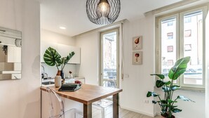 Una cocina moderna con una mesa de madera, sillas transparentes y una planta en maceta.