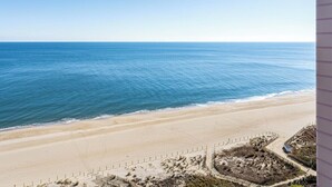 A beach view from a high-rise building with a clear sky.