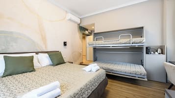 Deluxe vierpersoonskamer | Een kluis op de kamer, verduisterende gordijnen, geluiddichte muren