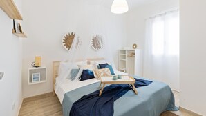 A neatly arranged bedroom with a bed, bedside table, and a bedside lamp.