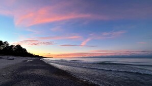 A beach with a pebbly shore and a calm sea. - Newberry U.P. Cabin (Newberry)