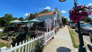 A quaint building with a sign reading "Alden's Coffin Tin" and a white picket fence. - Minutes to Torch Lake | Arcades | AC | Fenced Yard (Rapid City)