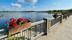 Un puente con jardineras de flores y vista a un lago tranquilo.
