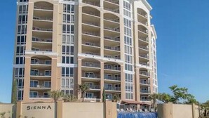 A multi-story hotel with balconies and a pool area. - Gorgeous Beachfront Condo with 
ocean views (Gulfport)