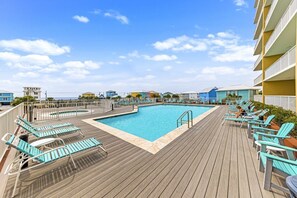 Ein Poolbereich mit Liegestühlen und einer Holzterrasse.