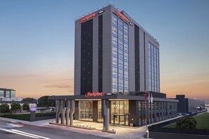Un hôtel Hampton moderne, avec une entrée imposante et de grandes fenêtres.