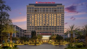 Een groot, meerhoog hotel met een opvallend Hilton Garden Inn bord.