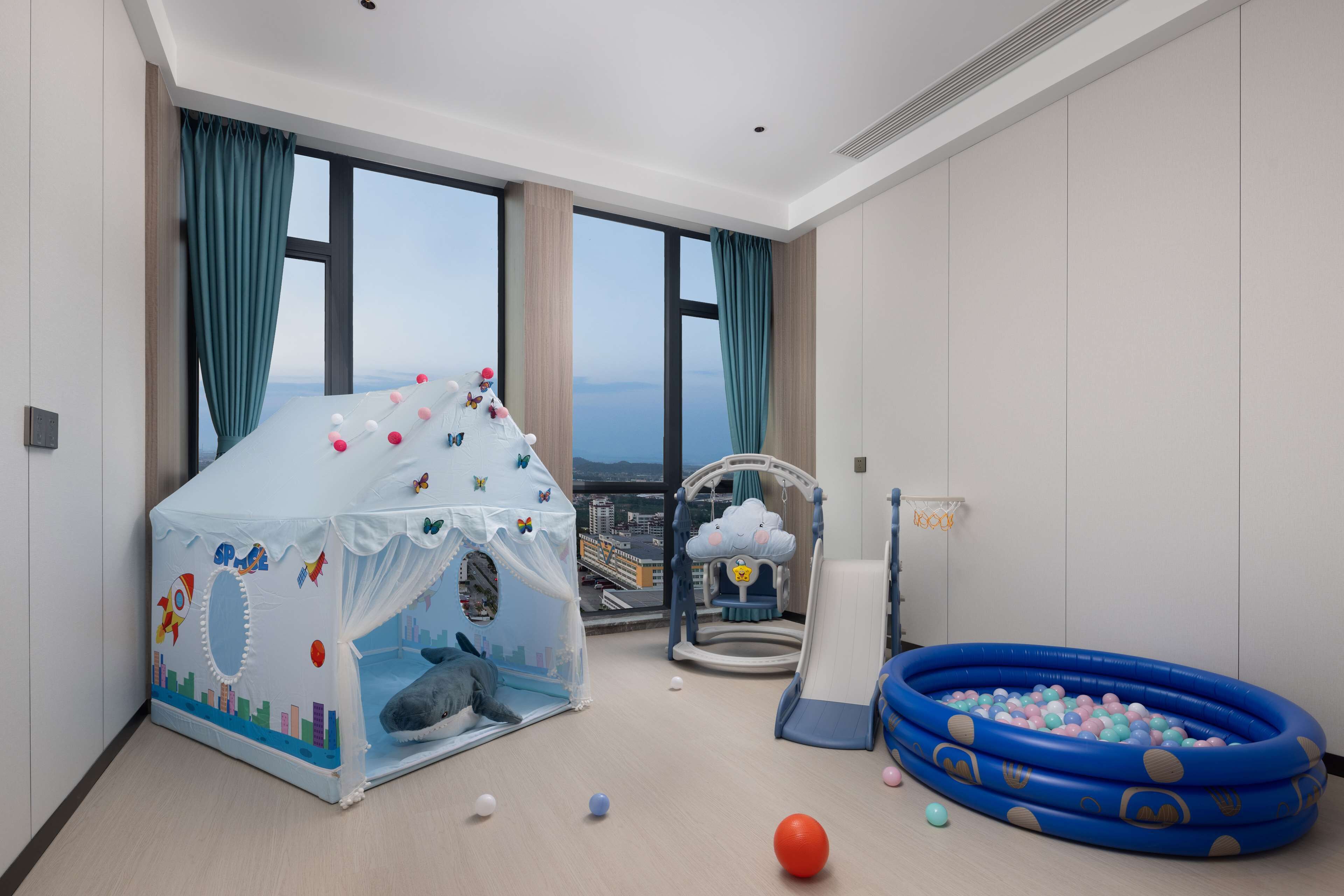 Ein Spielbereich für Kinder mit Zelt, Rutsche und Bällebad.