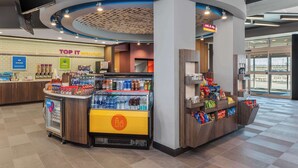 A breakfast area with a counter displaying various food items and a refrigerated display.
