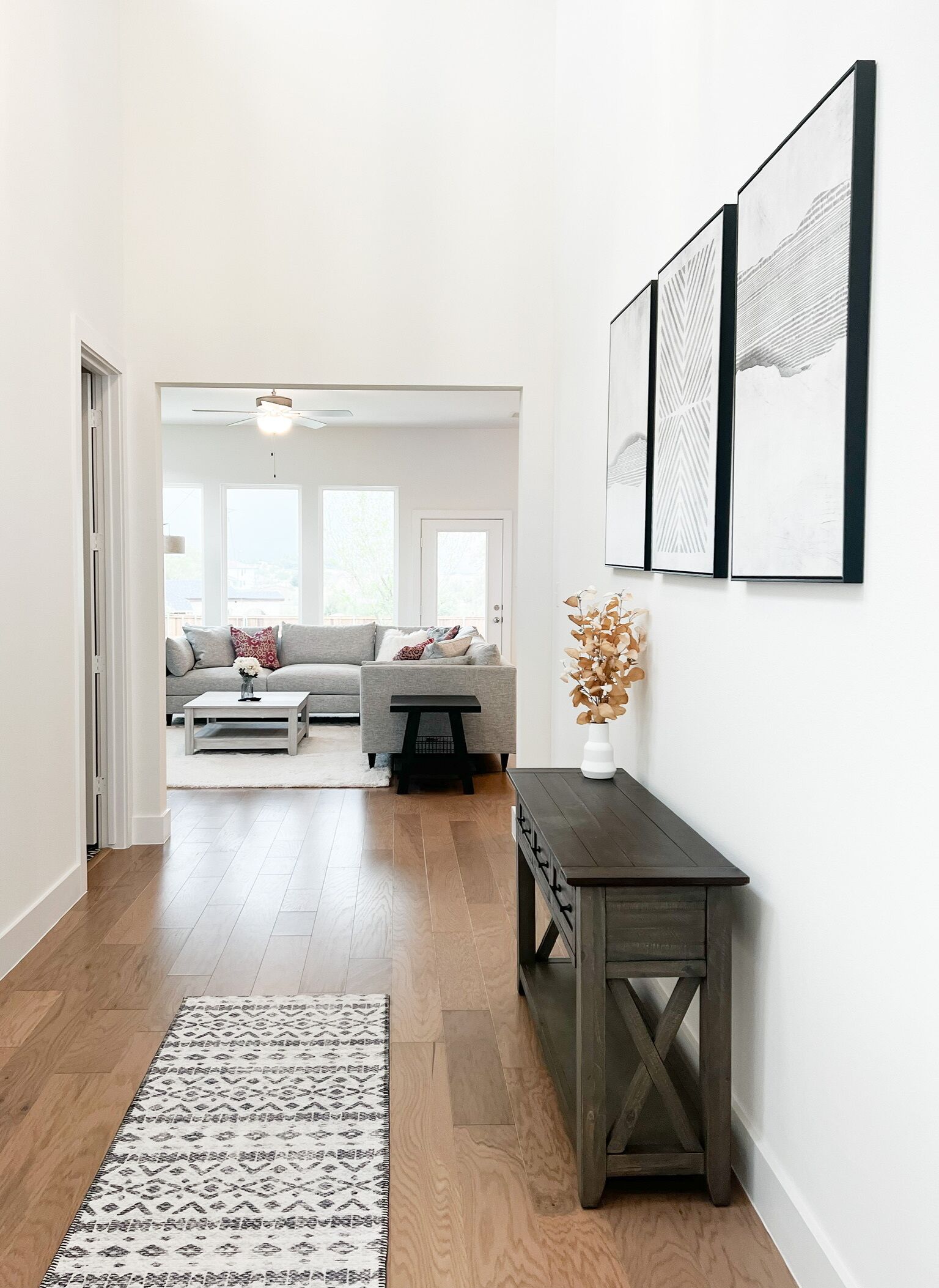A modern living room with a grey sofa, a coffee table, and a decorative vase.
