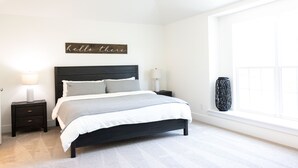 A bedroom with a bed, nightstands, a lamp, a vase, and a window.