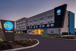 A modern hotel building with a prominent 'tru by Hilton' sign, multiple floors, and a well-lit entrance. - Tru By Hilton Merrillville (Merrillville)