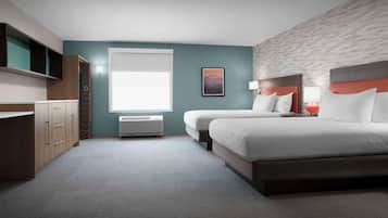 A hotel room with a large bed, a desk, a chair, and a window.